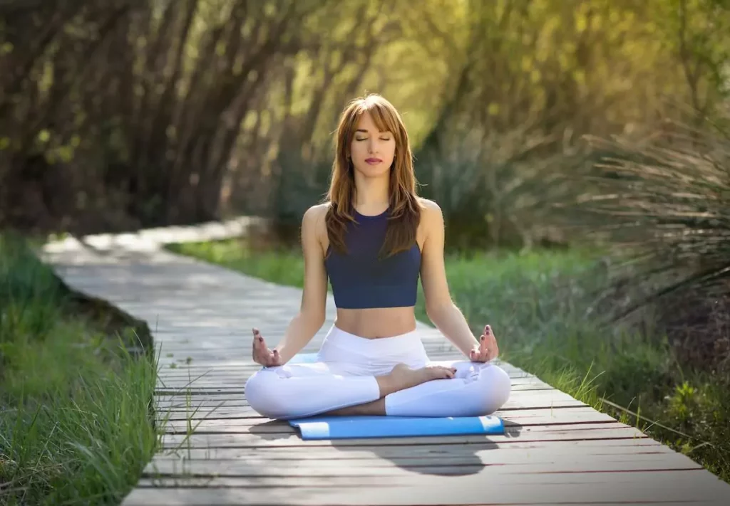 Señora calmada meditando en el bosque.