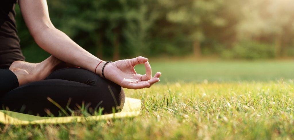 Una persona meditando en el bosque. 